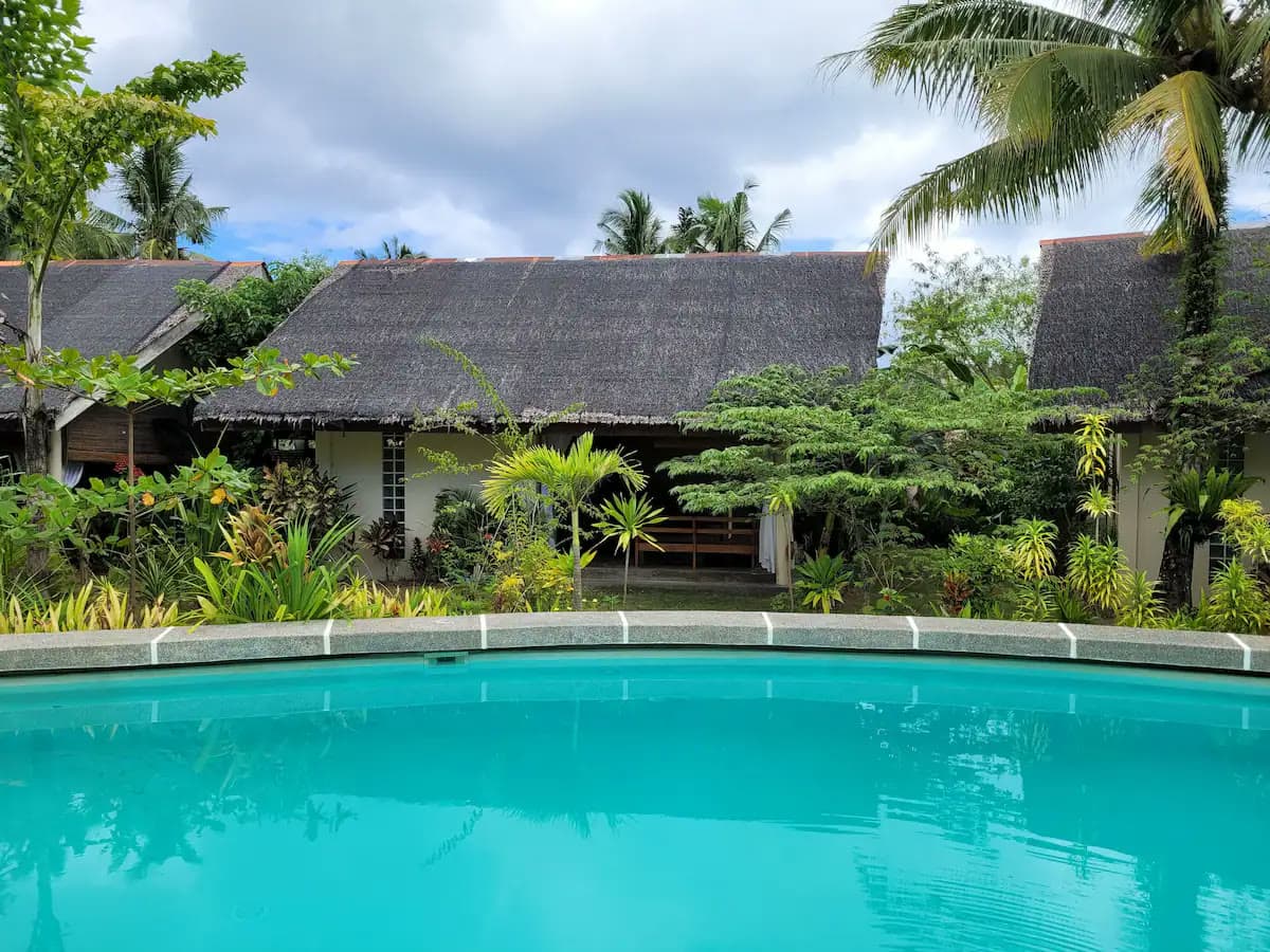 Outdoor swimming pool ringed by palms at Ohana Resort Siargao
